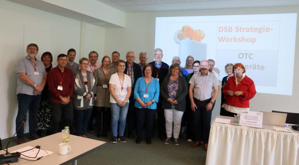 Gruppenbild der Teilnehmenden vor einer Leinwand
