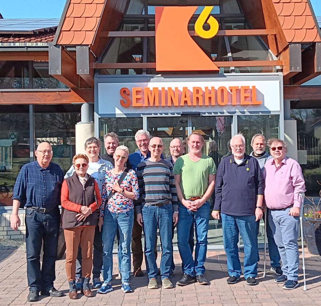 Männer und Frauen stehen für ein Gruppenfoto vor dem Hotel in Halberstadt und lächeln in die Kamera