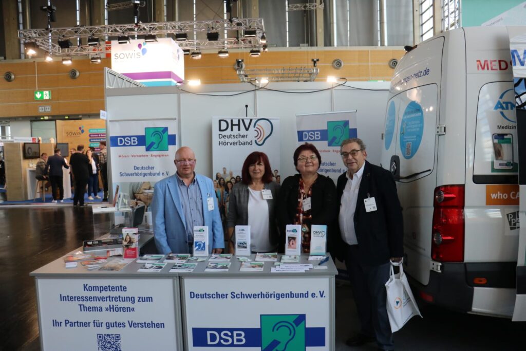 2 Frauen und 2 Männer stehen hinter einem Messestand für ein Gruppenbild